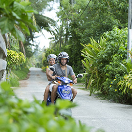 couple conduisant un scooter dans les chemins de polynésie française