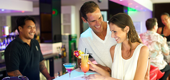 Couple en train de boire un cocktail polynésien au bar de l'hôtel Manava Suite Resort